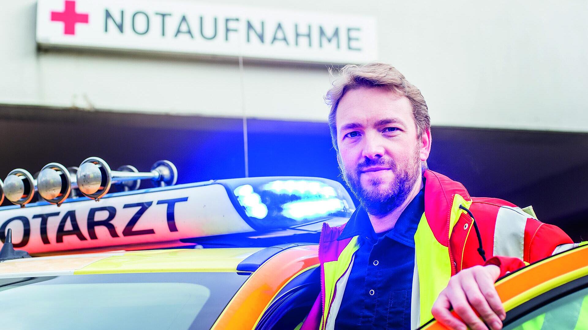 Notarzt steigt vor einer Notaufnahme aus einem Rettungswagen