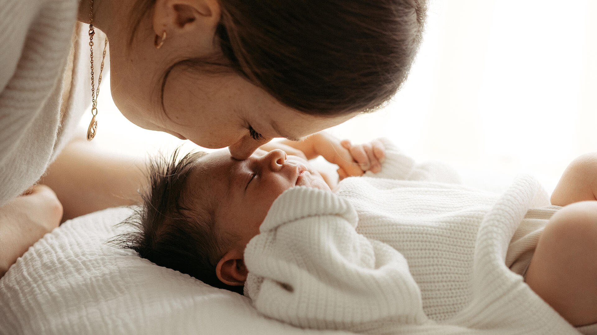 Klinikreportage am St. Josefskrankenhaus Freiburg, Mutter küsst Baby auf Stirn, Marina Müller Fotografie